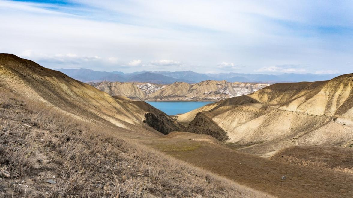 En la orilla del embalse de Toktogul, el agua refleja las montañas circundantes.